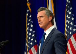 Gavin Newsom in front of United States Flags